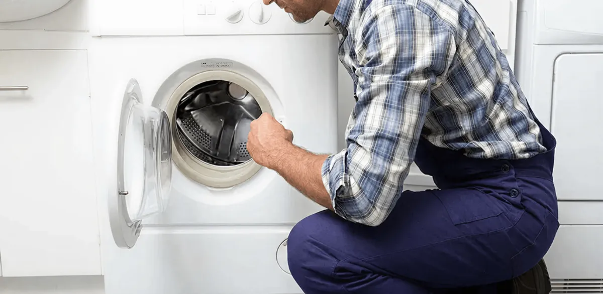 Handyman inspecting a dryer drum and internal parts for repair in Tempe, AZ