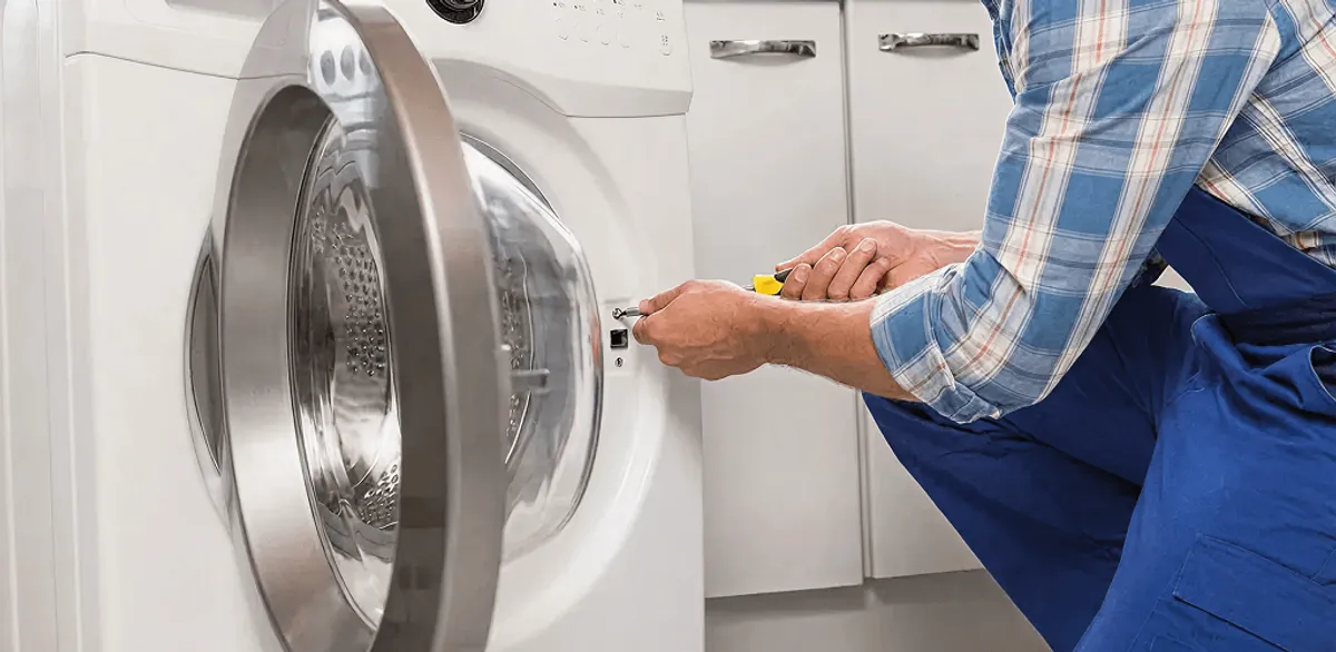 Handyman repairing a clothes dryer and checking electrical connections in Tempe, AZ
