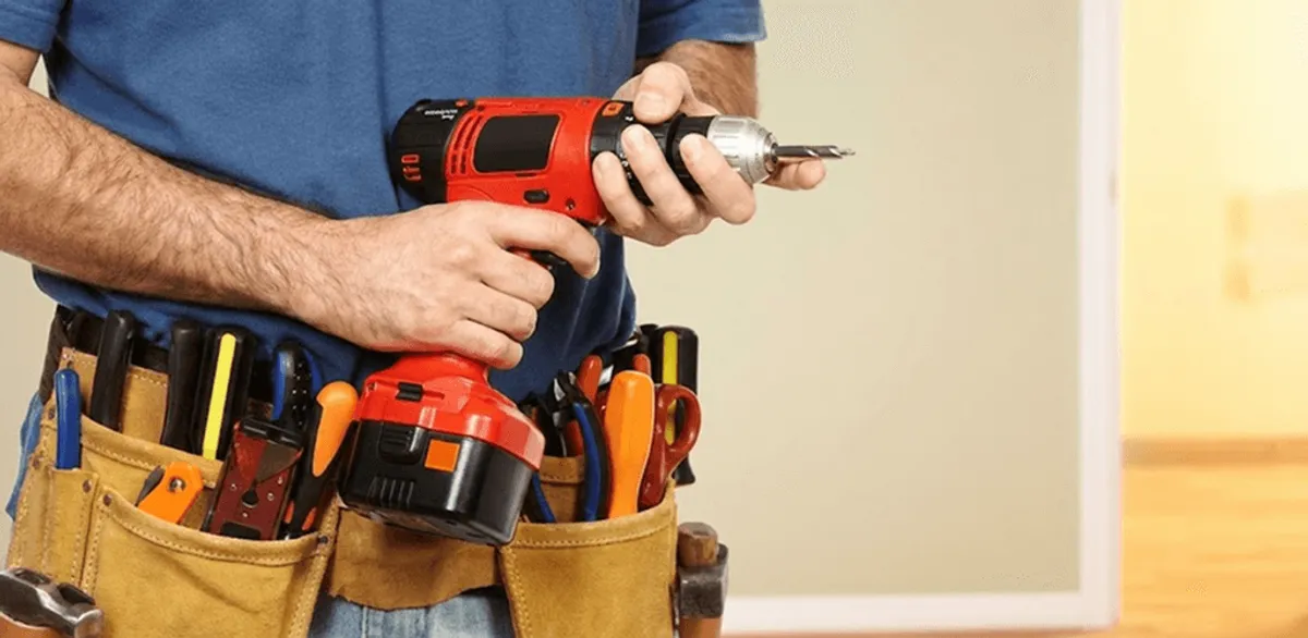 Handyman holding a power drill for home repairs and installations in Tempe, AZ