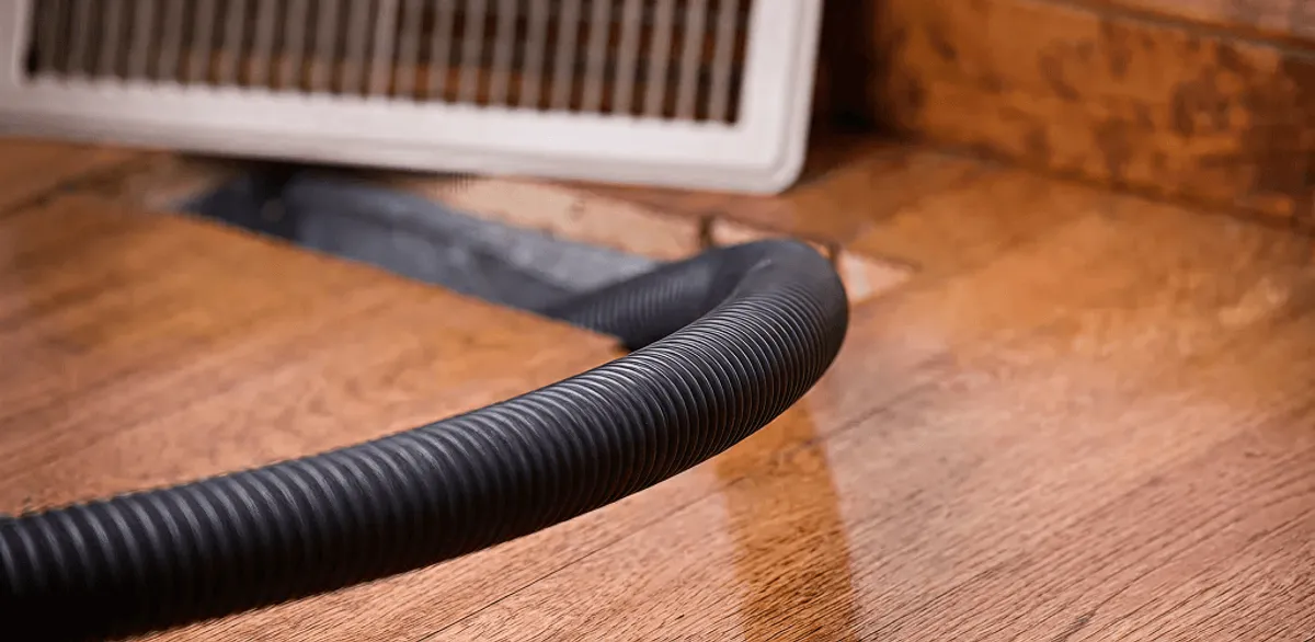 Air duct cleaning hose inserted into a floor vent for ductwork cleaning in Tempe, AZ