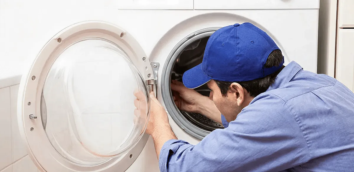 Washing machine repair handyman inspecting a front-load washer drum in Tempe, AZ